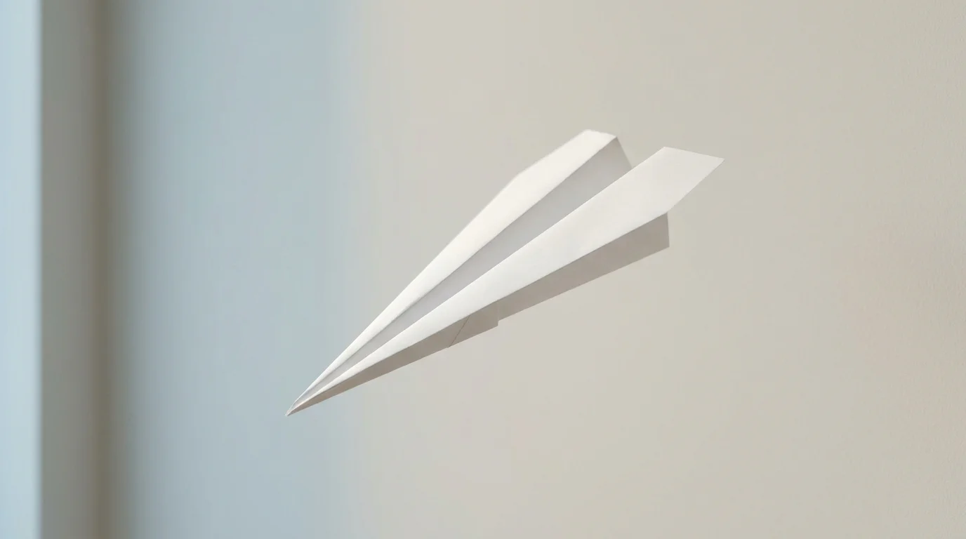 Papierflieger im Aufstieg vor einer schlichten hellen Wand